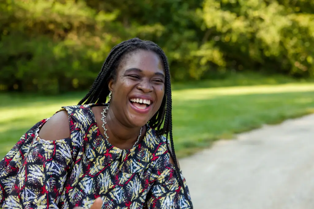 A mom laughs as she enjoys an evening with her family at the park.